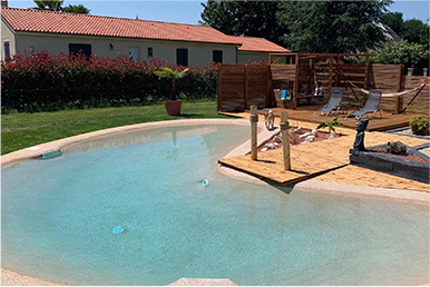 Piscine lagon NaturaSwim bordée d'une élégante terrasse en Côtes d'Amor
